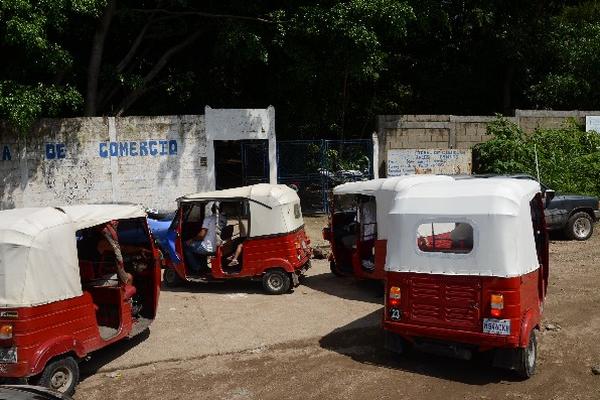 Varios  mototaxis hacen  fila frente a la Escuela  de Comercio, de Cuilapa,   a la espera  de la salida de   estudiantes.