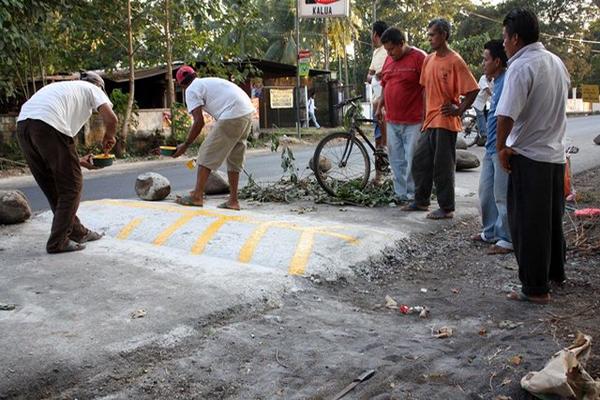 Vecinos construyen túmulos en la ruta entre Retalhuleu y Champerico. (Foto Prensa Libre: Rolando Miranda)<br _mce_bogus="1"/>