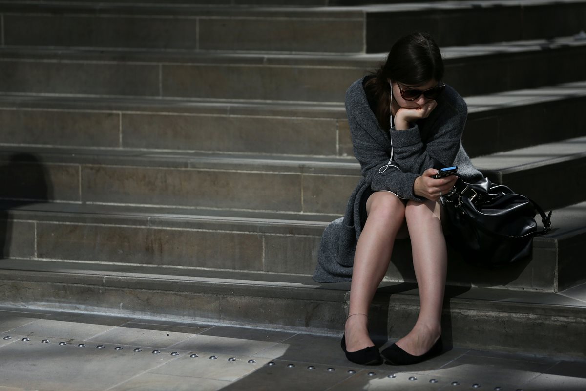 Una joven revisa su teléfono móvil en Londres, líder en el listado de las mejores ciudades del mundo para vivir. (Foto Prensa Libre: AFP).