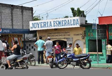 Curiosos observan el comercio saqueado.