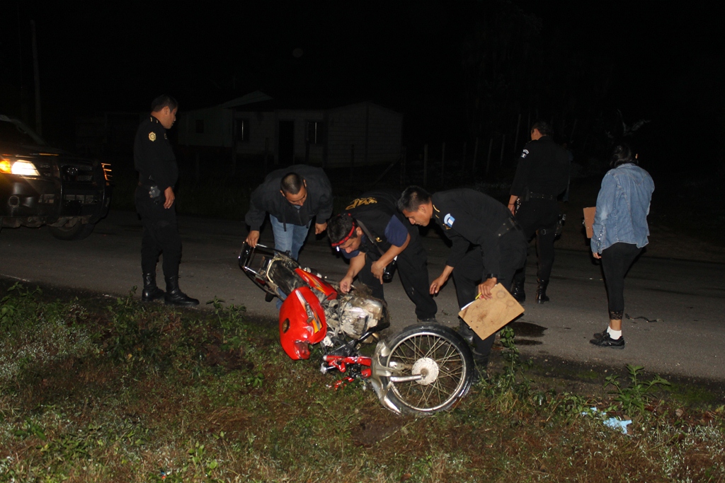 Agentes de la PNC inspeccionan la motocicleta accidentada en Poptún, Petén. (Foto Prensa Libre: Walfredo Obando)