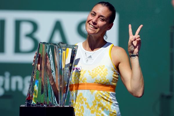 La italiana celebra sonriente con el trofeo que la acredita como campeona. (Foto Prensa Libre: AP)