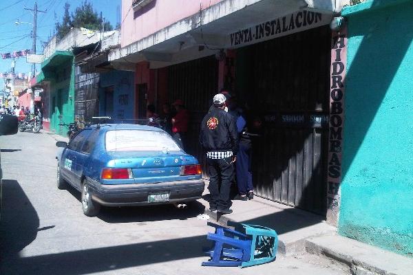 curiosos observan el negocio donde fue muerto a balazos Manuel Hernández Pérez.