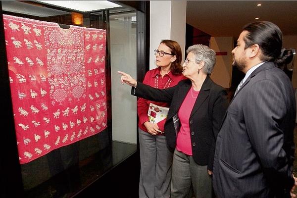 Bárbara  de Arathoon, Rosario de Polanco y Daniel Aquino  observan el huipil elaborado en el siglo XIX. (Foto Prensa Libre: Edwin Castro)