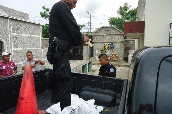 Agentes de la Policía Nacional Civil trasladan el cadáver de la niña a la morgue.