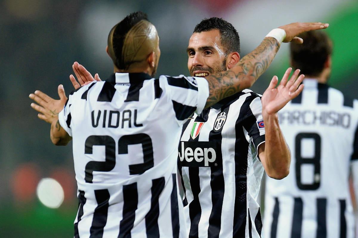 El chileno Arturo Vidal y el argentino Carlos Tevez celebran el pase de la Juventus a cuartos de final de la Liga de Campeones. (Foto Prensa Libre: AFP)