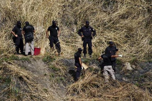 Policías investigan la escena de un crimen en Ciudad Delgado, El  Salvador, perpetrado en enero de 2015. Las pandillas son las principales  responsables de los hechos violentos en este país. (Foto Prensa Libre:  AFP).