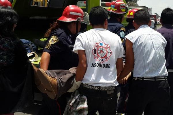 Bomberos Municipales Departamentales trasladan a uno de los heridos. (Foto Prensa Libre:)<br _mce_bogus="1"/>