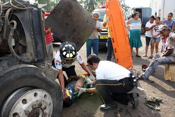 Socorristas atienden a una de las personas que resultó lesionada por un accidente laboral con un tráiler en San Sebastián, Retalhuleu. (Foto Prensa Libre: Rolando Miranda)<br _mce_bogus="1"/>