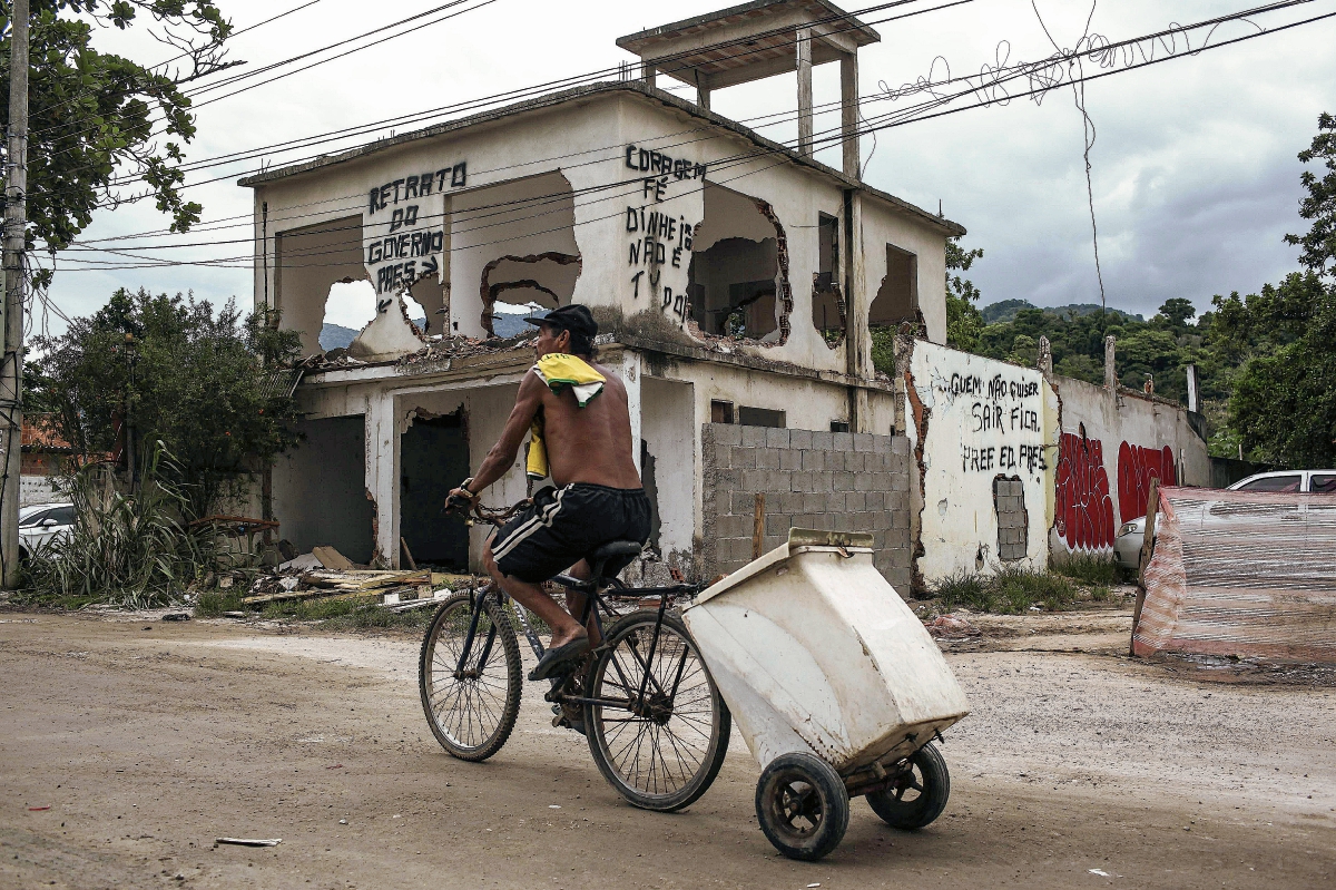 Un hombre pasa en bicicleta frente a una favela en Río de Janeiro. (Foto Prensa Libre: EFE)