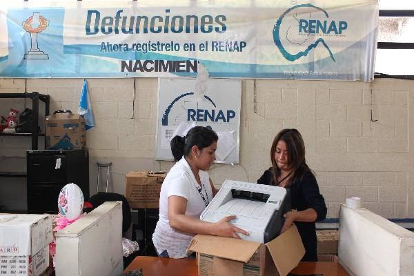 Empleadas del Renap empacan el equipo de cómputo para completar el traslado.