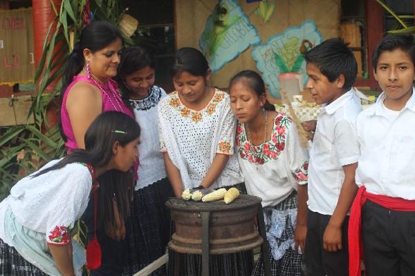 grupo de estudiantes   asan  elotes, como parte  de  las actividades  del festival.