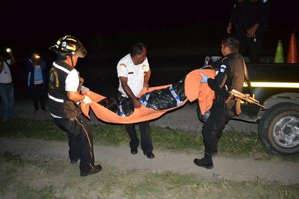 Agentes levantan el cadáver de una mujer no identificada que murió arrollada por un tráiler. (Foto Prensa Libre: Hugo Oliva)<br _mce_bogus="1"/>