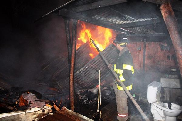 Un bombero trabaja para sofocar las llamas y evitar que estas se extiendan a otras viviendas de Retalhuleu. (Foto Prensa Libre: Rolando Miranda)<br _mce_bogus="1"/>