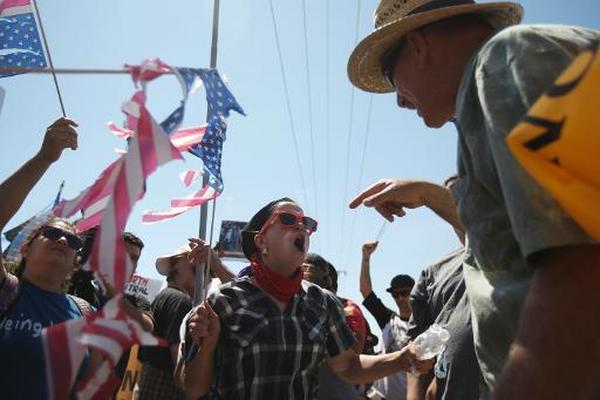 Unos manifestantes opuestos a la llegada de indocumentados se enfrentan a  otros favorables, en Murrieta, California, EE. UU. (Foto Prensa Libre:  AFP).