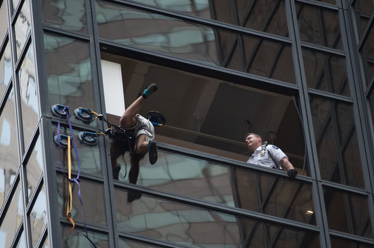 Momento en que el escalador es capturado por la Policía. (Foto Prensa Libre: AFP).