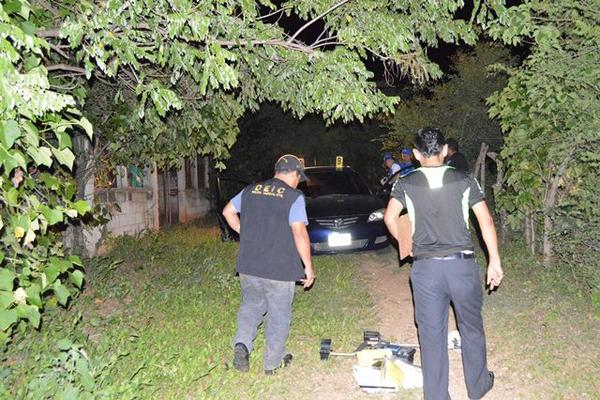 Peritos del Ministerio Público buscan indicios junto al vehículo donde  fueron encontrados los cuerpos de una pareja, en San Jorge, Zacapa.  (Foto Prensa Libre: Víctor Gómez)