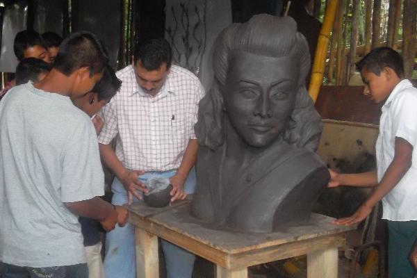 El maestro Ytay Martínez —al centro— explica a sus alumnos  cómo esculpió el busto.