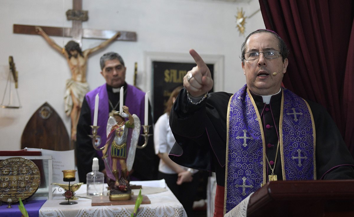 El obispo Manuel Acuña (a la der.) ora durante un ritual en la parroquia El Buen Pastor, en las afueras de Buenos Aires. (Foto Prensa Libre: AFP).