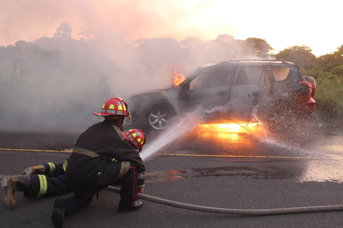 Bomberos sofocan las llamas del vehículo. (Foto Prensa Libre: Alexander Coyoy)