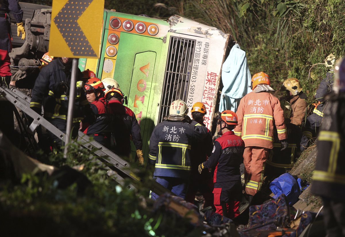 Rescatistas recuperan cuerpos de víctimas del accidente de autobús en Taipei, Taiwán. (Foto Prensa Libre:AP).