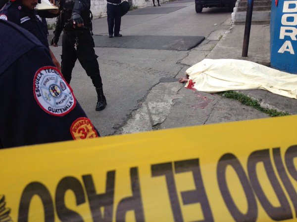 Los Bomberos Municipales cubren el cadáver del menor, muerto a balazos en la zona 13. (Foto Prensa Libre: Cortesía CBM)