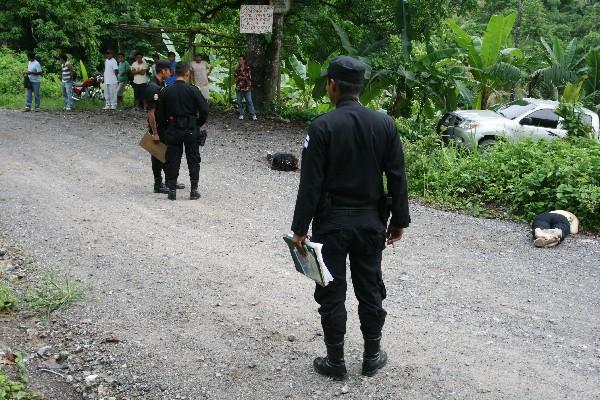 Policías observan  cadáveres de mujeres.