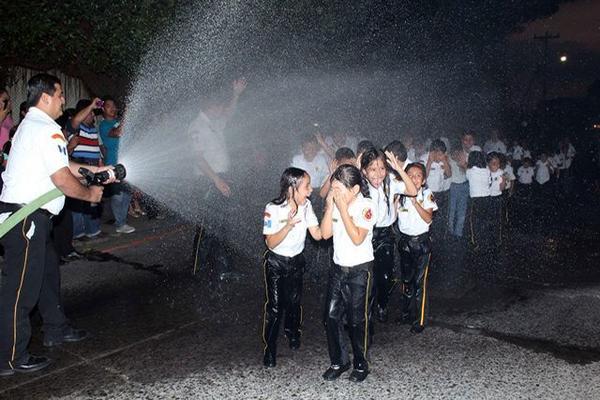 Bombero moja a los nuevos socorristas infantiles que se graduaron en Retalhuleu. (Foto Prensa Libre: Rolando Miranda) <br _mce_bogus="1"/>