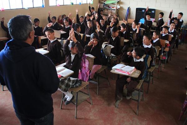 Estudiantes de la Escuela de San José Las Flores, Chiantla,  Huehuetenango, levantan la mano cuando su maestro les pregunta cuántos  de ellos tienen familiares en EE. UU. (Foto Prensa Libre: Mike Castillo)