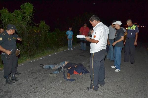 Agentes observan el cadáver.