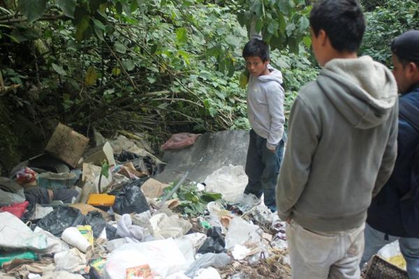 Niños que recolectaban chatarra fueron los que localizaron el cadáver en el barranco El Condenado. (Foto Prensa Libre: Víctor Chamalé)<br _mce_bogus="1"/>