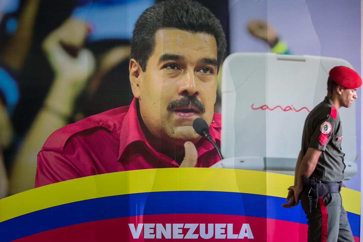 Un militar venezolano camina frente a una pared con la imagen del presidente de Venezuela Nicolás Maduro, en Venezuela. (Foto Prensa Libre: EFE)