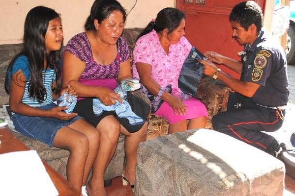 Yesenia López Domingo, 10, llora, mientras su madre Albertina Domingo y la vecina María Elena Godínez son auxiliadas por un socorrista.