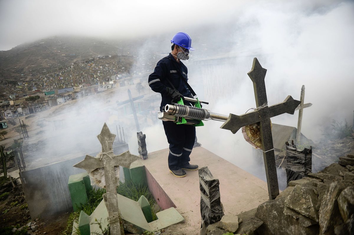 Un hombre fumiga un área del cementerio Nueva Esperanza en Lima, Perú, para evitar la propagación del mosquito. (Foto Prensa Libre: AFP).