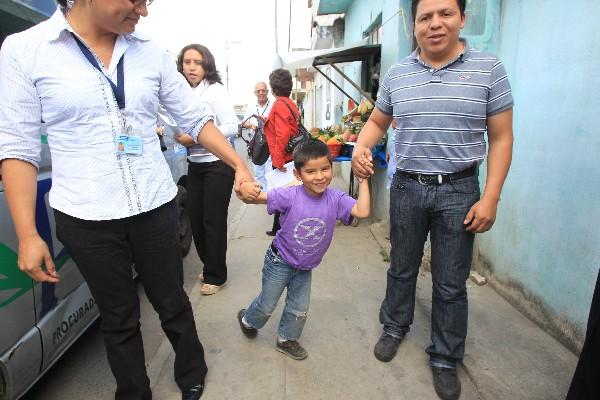 El niño José Carlos González, junto a personal de la PGN, sale en busca de sus familiares.