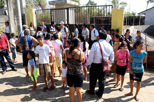 Padres de familia, acompañados de sus hijos, denuncian que no pudieron ingresar al establecimiento porque tenía candados. (Foto Prensa Libre: Rolando Miranda)