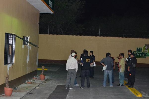 Fiscales del Ministerio Público y agentes de la PNC recolectan evidencias en el exterior del banco asaltado en Teculután. (Foto Prensa Libre: Érick de La Cruz)<br _mce_bogus="1"/>