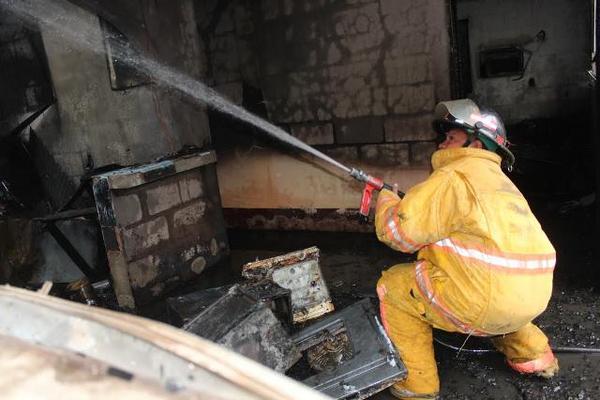 Socorristas trabajaron más de una hora para sofocar el incendio en una vivienda en Izabal. (Foto Prensa Libre: Edwin Perdomo)<br _mce_bogus="1"/>