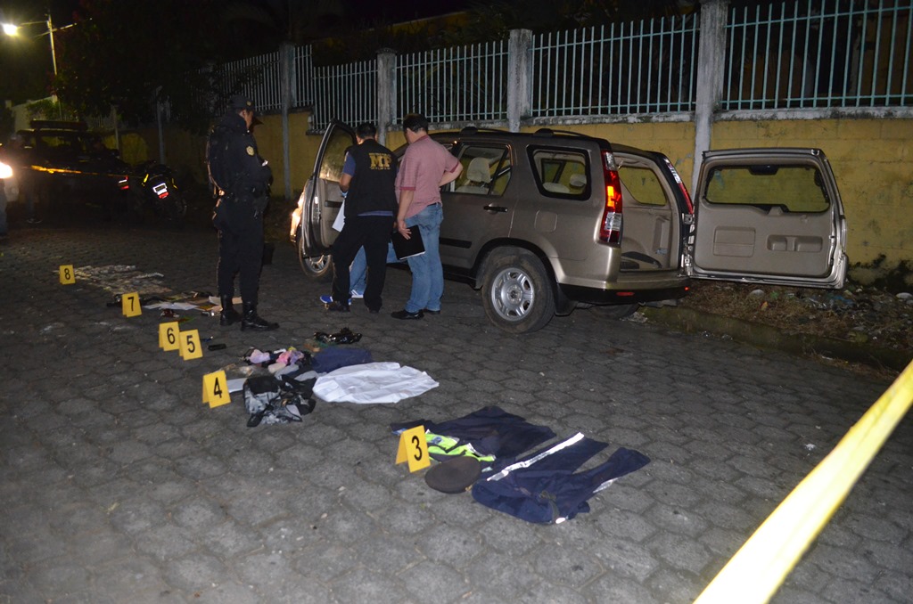 Las autoridades revisan el vehículo abandonado en la zona 4 de Retalhuleu, donde se encontró un arma de fuego y otros artículos. (Foto Prensa Libre: Jorge Tizol)