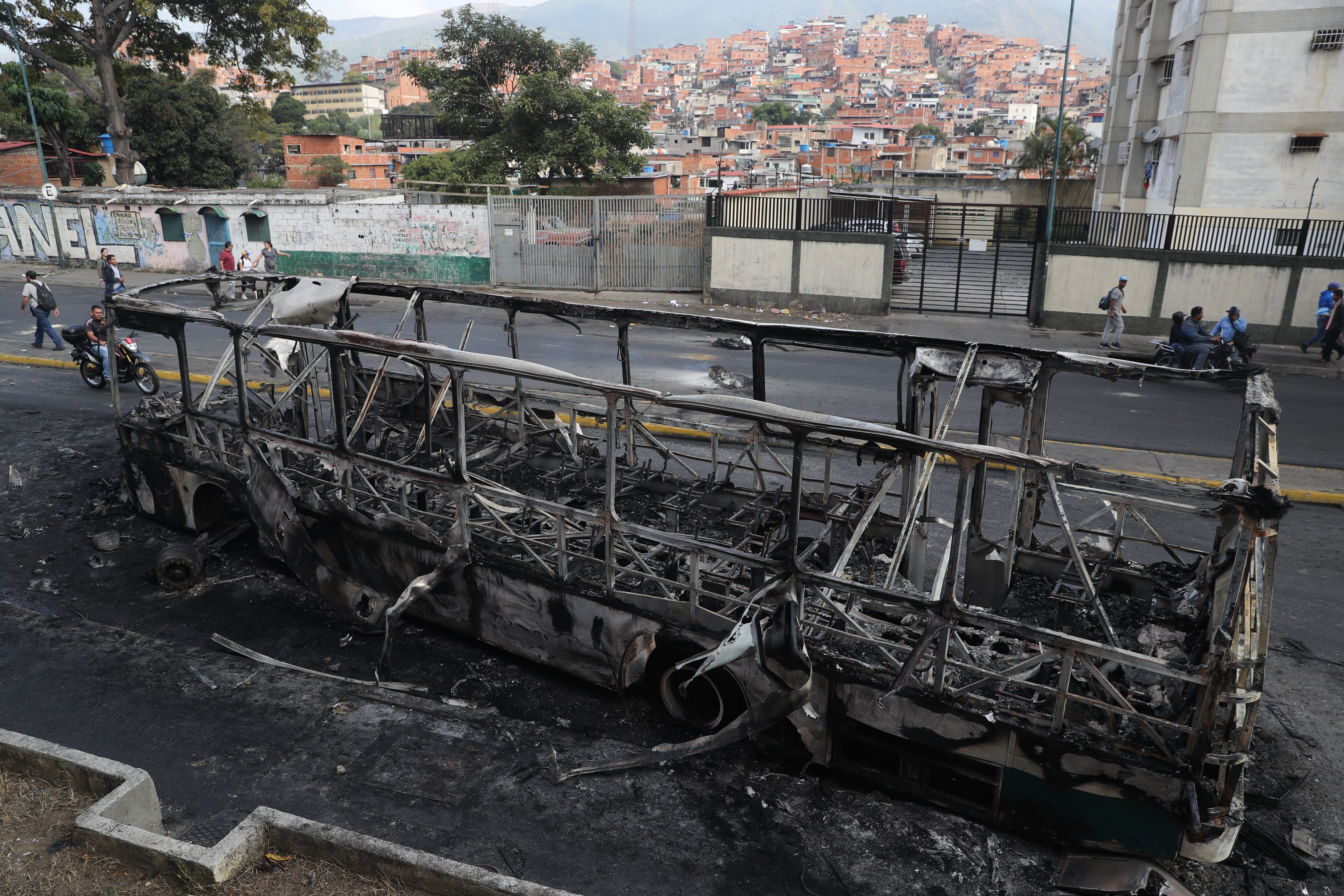 Vista de un autobús incendiado en la madrugada de este miércoles en Caracas. (Foto Prensa Libre: EFE)