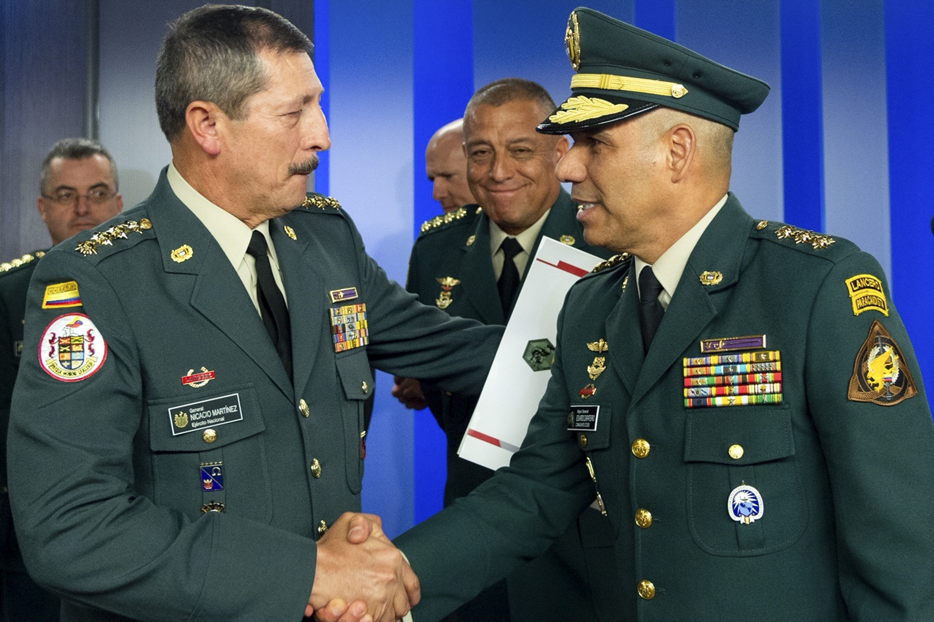 el comandante del ejército colombiano general retirado Nicacio Martínez (L) saludando a su reemplazo, el general Eduardo Zapateiro, en el palacio presidencial de Narino en Bogotá, Colombia. (Foto Prensa Libre: AFP)