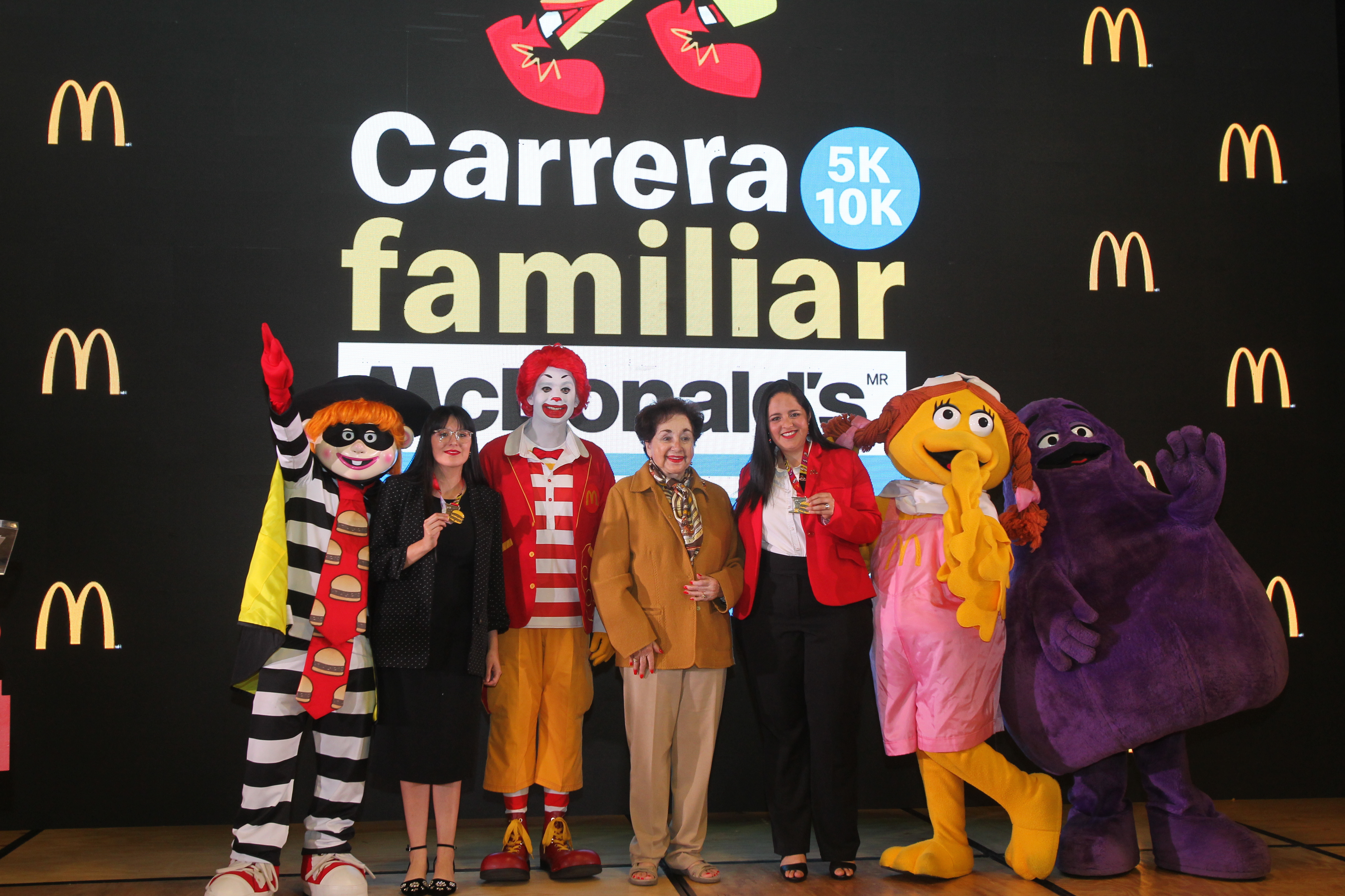 Doña Yolanda Cofiño -al centro-, rodeada de ejecutivos de McDonald´s y los personajes, presentaron la Carrera Familiar. (Foto Prensa Libre: Norvin Mendoza)