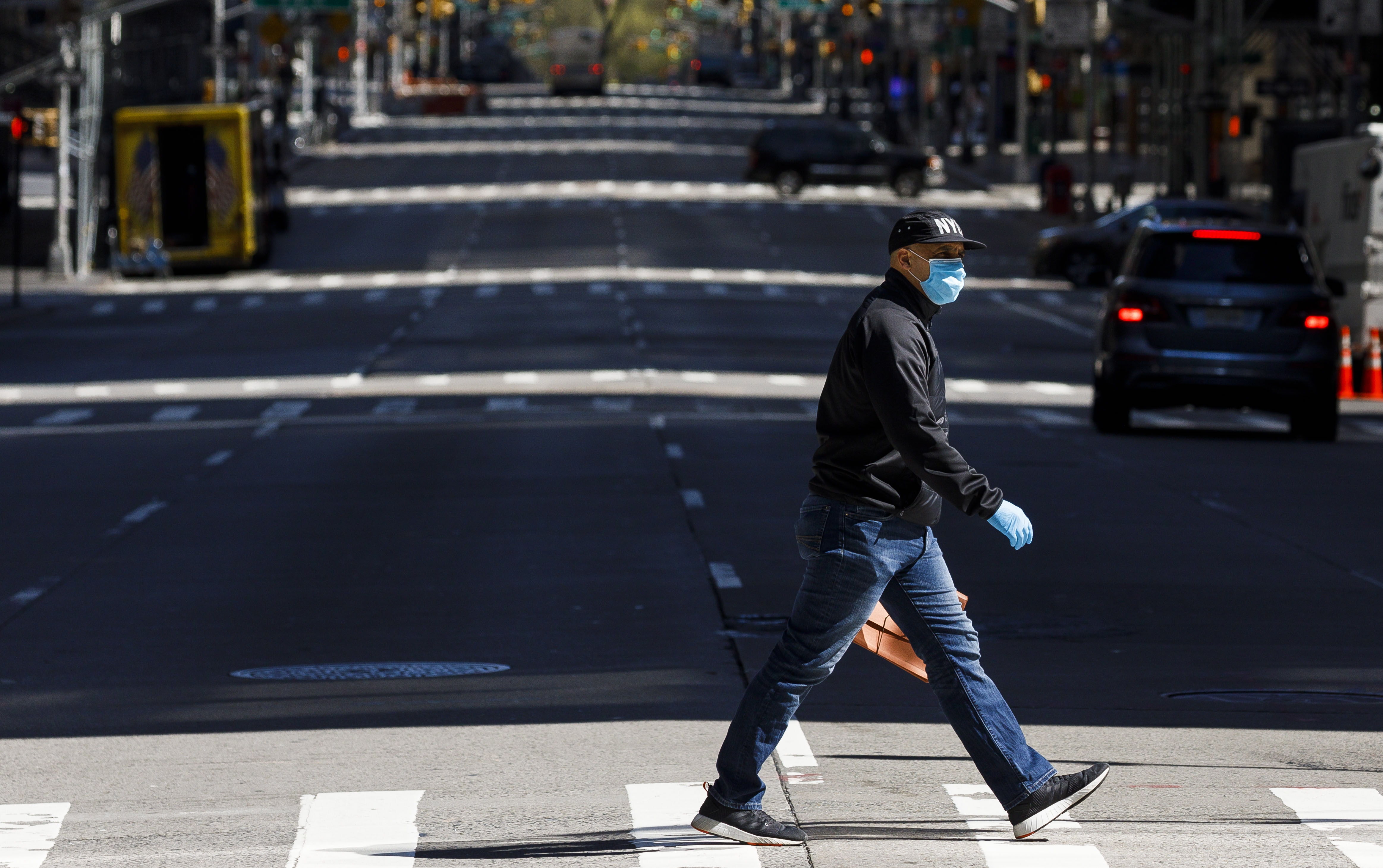 New York (United States), 15/04/2020.- A man in a mask crosses 6th avenue in New York, New York, USA, 15 April 2020. New York Governor announced plans to issue an executive order that will require everyone to wear a mask or face covering while in public. Restrictions requiring the shut down of all non-essential businesses are still in place around the United States to stop the spread of the highly-contagious coronavirus which are having massive economic implications. Politicians and public health officials are begining to suggest plans for lifting some rules in an effort to get parts of the economy going again; many health officials are worried this will lead to another spike in COVID-19 cases. (Estados Unidos, Nueva York) EFE/EPA/JUSTIN LANE