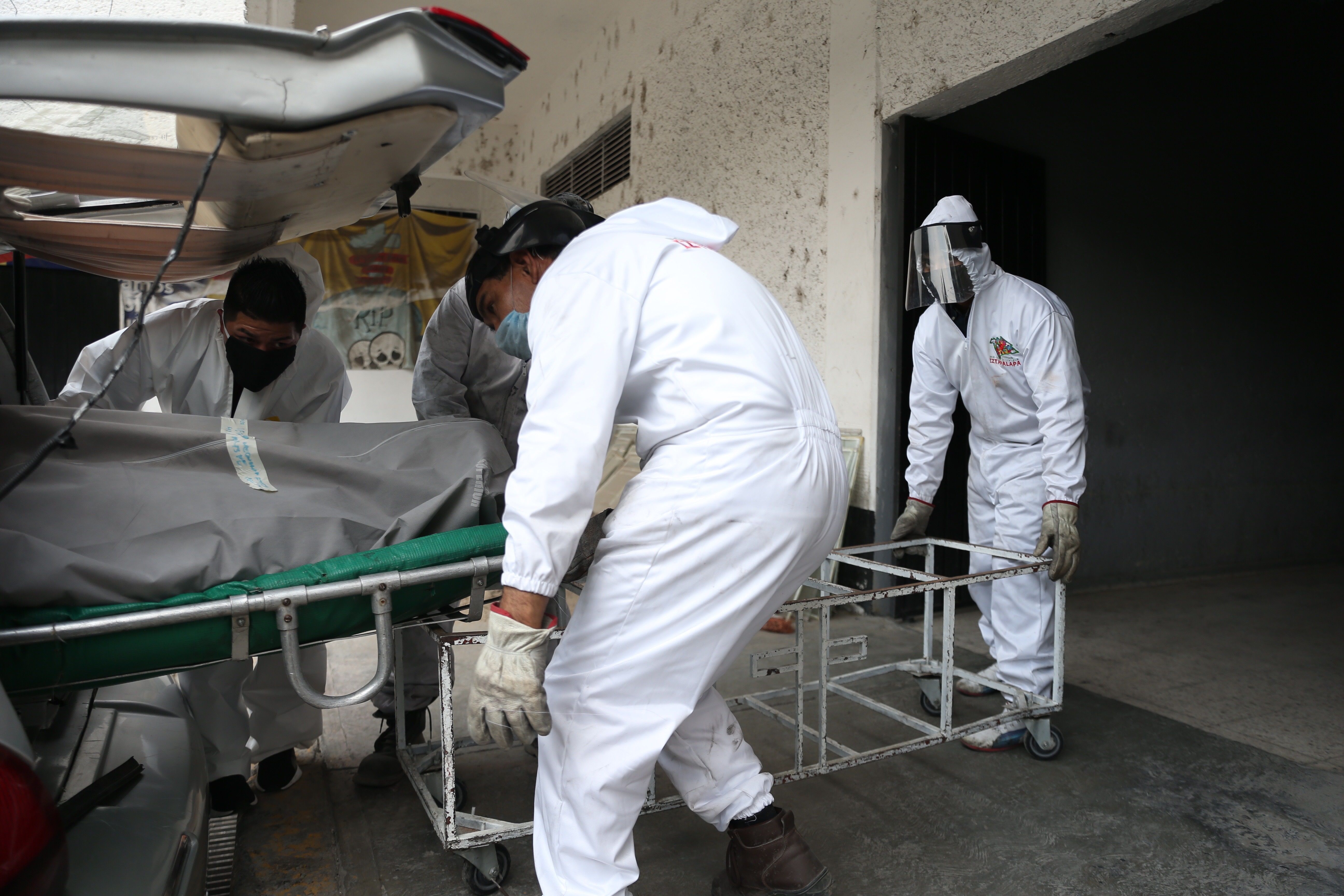 Trabajadores del Panteón de San Nicolás Tolentino, en la Alcaldía de Iztapalapa en Ciudad de México, trasladan a la zona de crematorios el cuerpo de una persona fallecida debido a la pandemia del COVID-19. México superó ayer el millar de muertos de COVID-19, con 1.069 defunciones y llegó a 11.633 contagios acumulados, un 10,6 % más frente a los 10.544 del reporte previo, informaron las autoridades sanitarias del país. (Foto Prensa Libre: EFE)