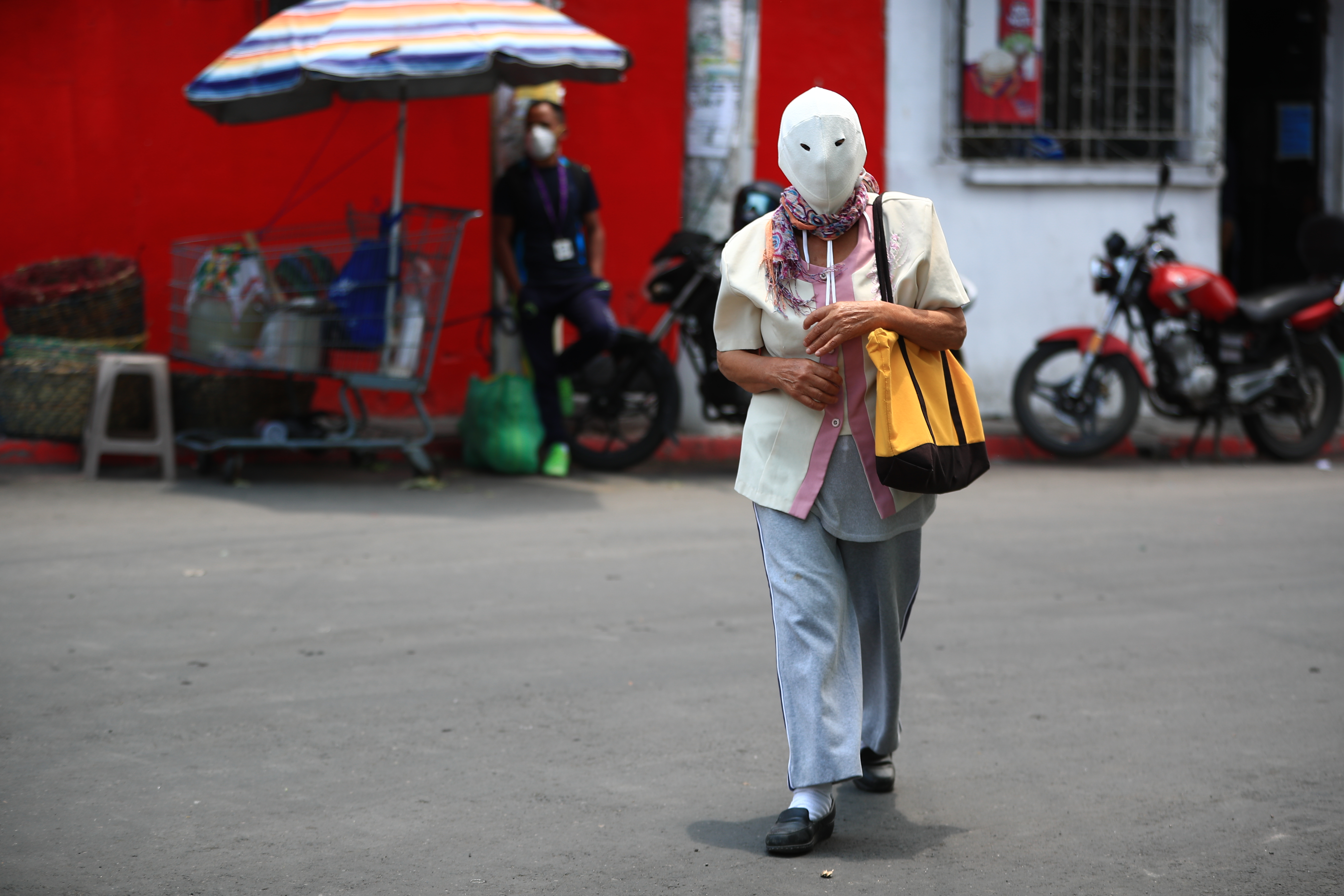 Una vecina de Villa Hermosa porta una mascarilla que le cubre toda la cabeza, ella procura salir de su casa solo para comprar alimentos. (Foto Prensa Libre: Carlos Hernández) 