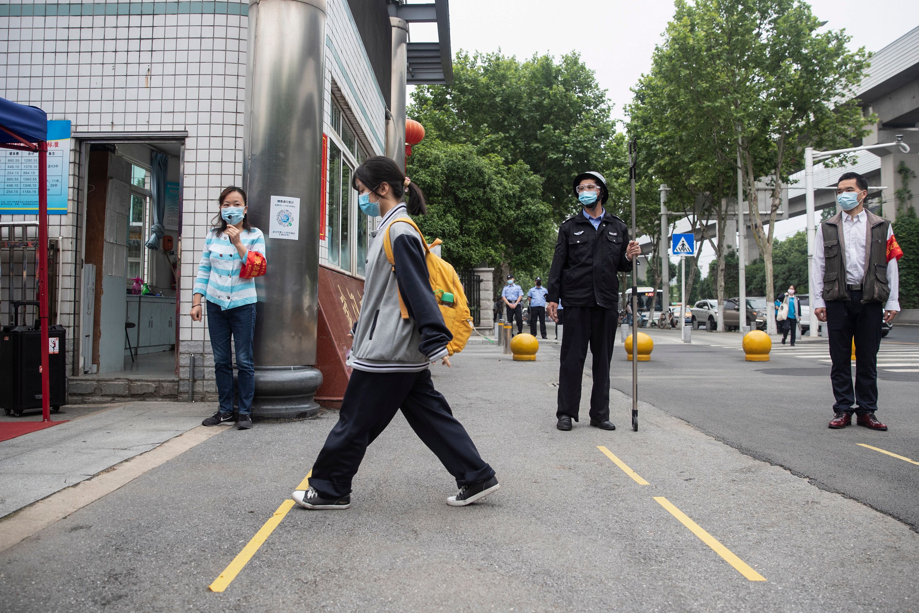 Estudiantes entran a un centro educativo de Wuhan, China. (Foto Prensa Libre: AFP)