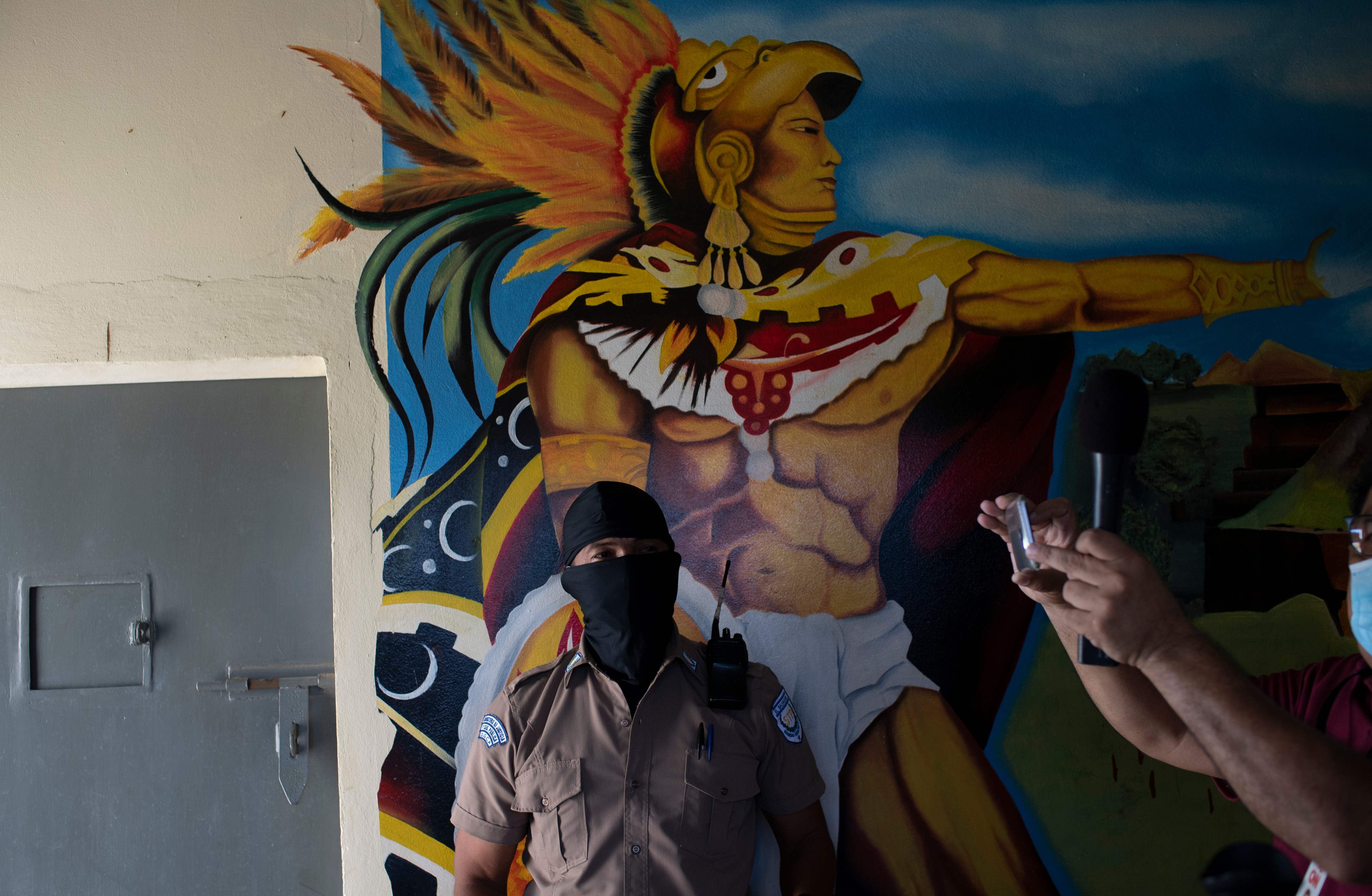 Un guardia penitenciario captado frente a un mural de la prisión de Quezaltepeque, El Salvador. (Foto Prensa Libre: AFP)