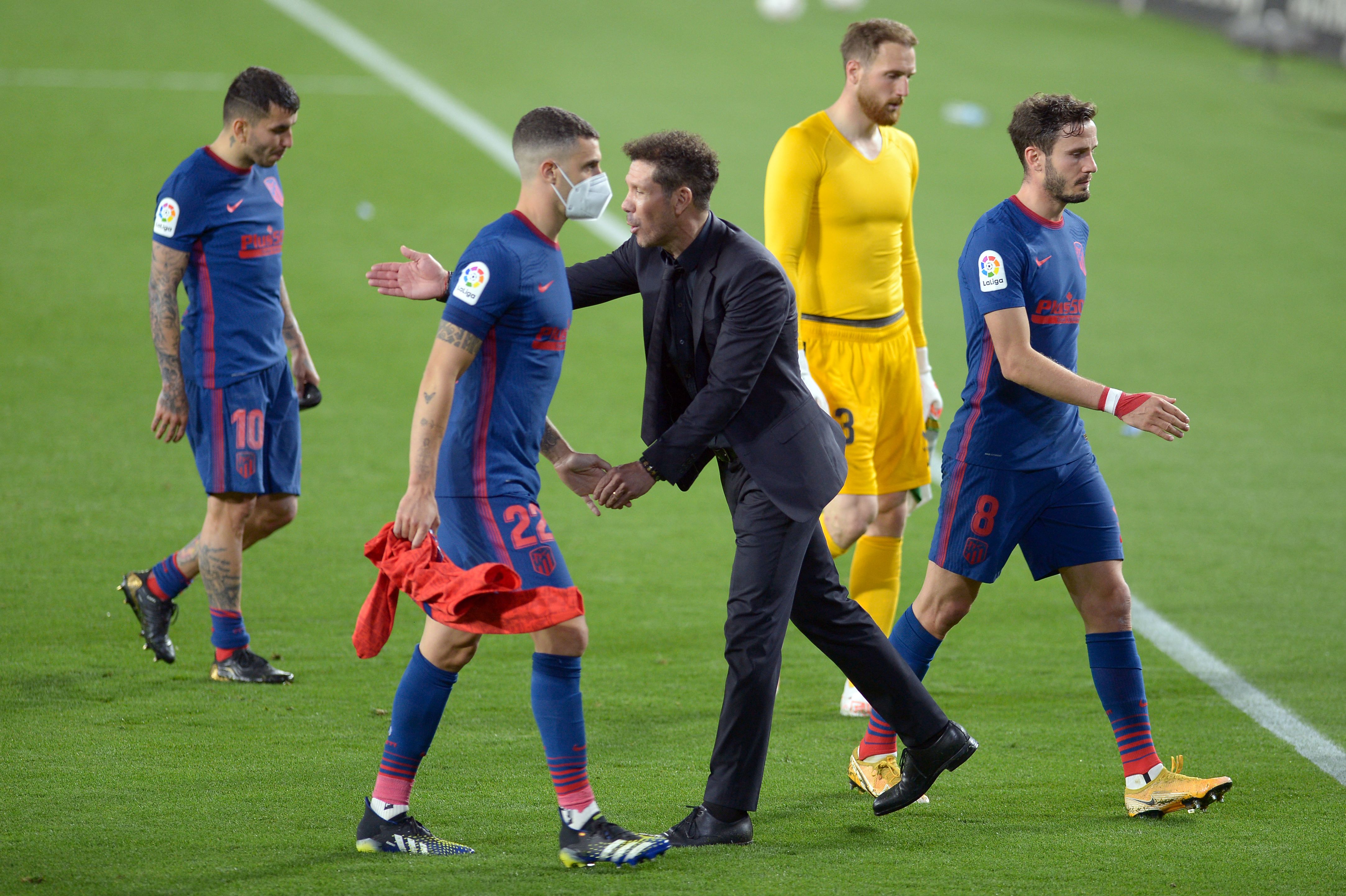 El técnico 
Diego Simeone felicita a sus jugadores después de empatar de visita contra el Real Betis, resultado que les permitió seguir de lideres. (Foto Prensa Libre: AFP).