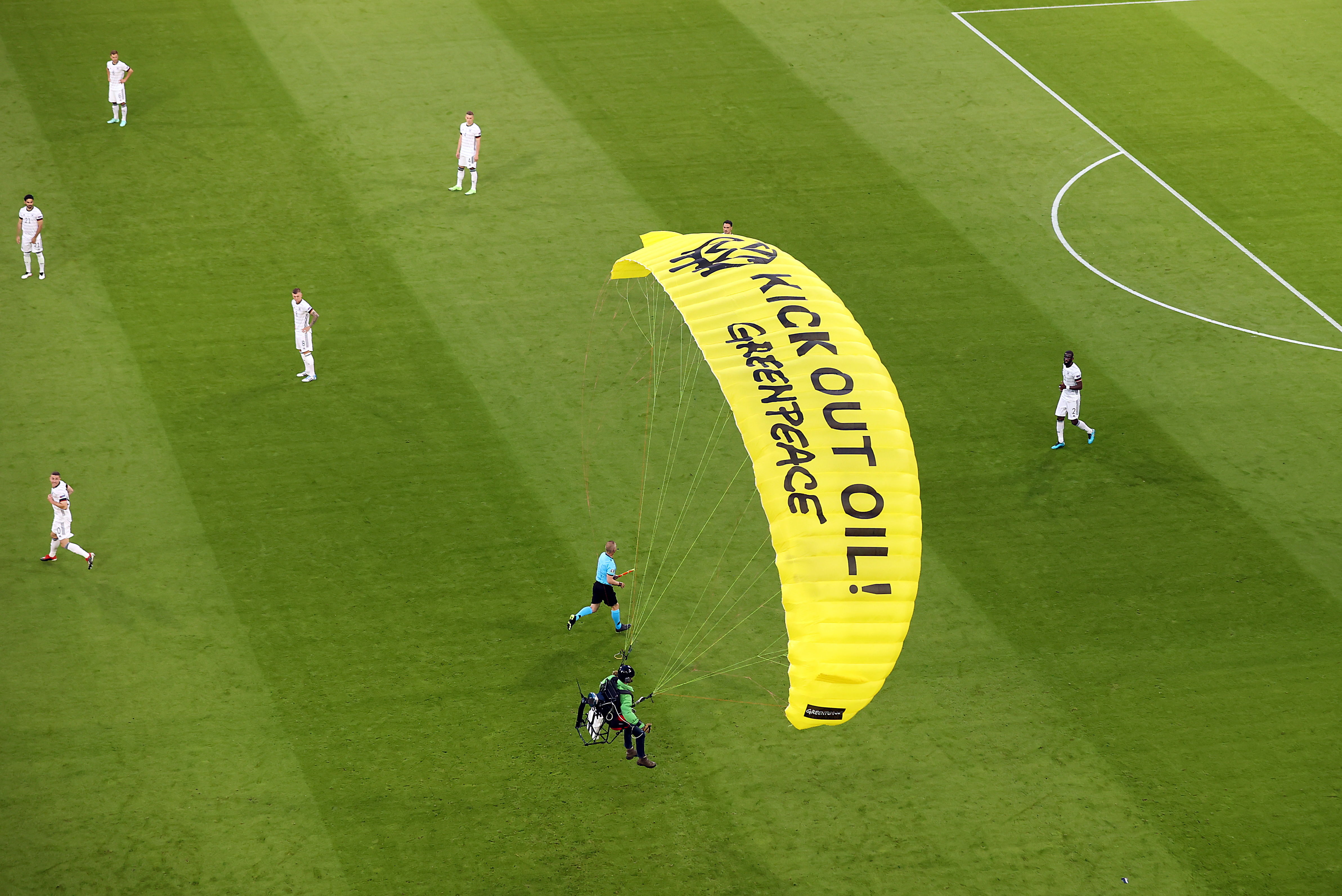 Un activista de la organización  Greenpeace se lanzó en un paracaídas antes de que diera inicio el juego de Francia vs. Alemania. Foto Prensa Libre: EFE.