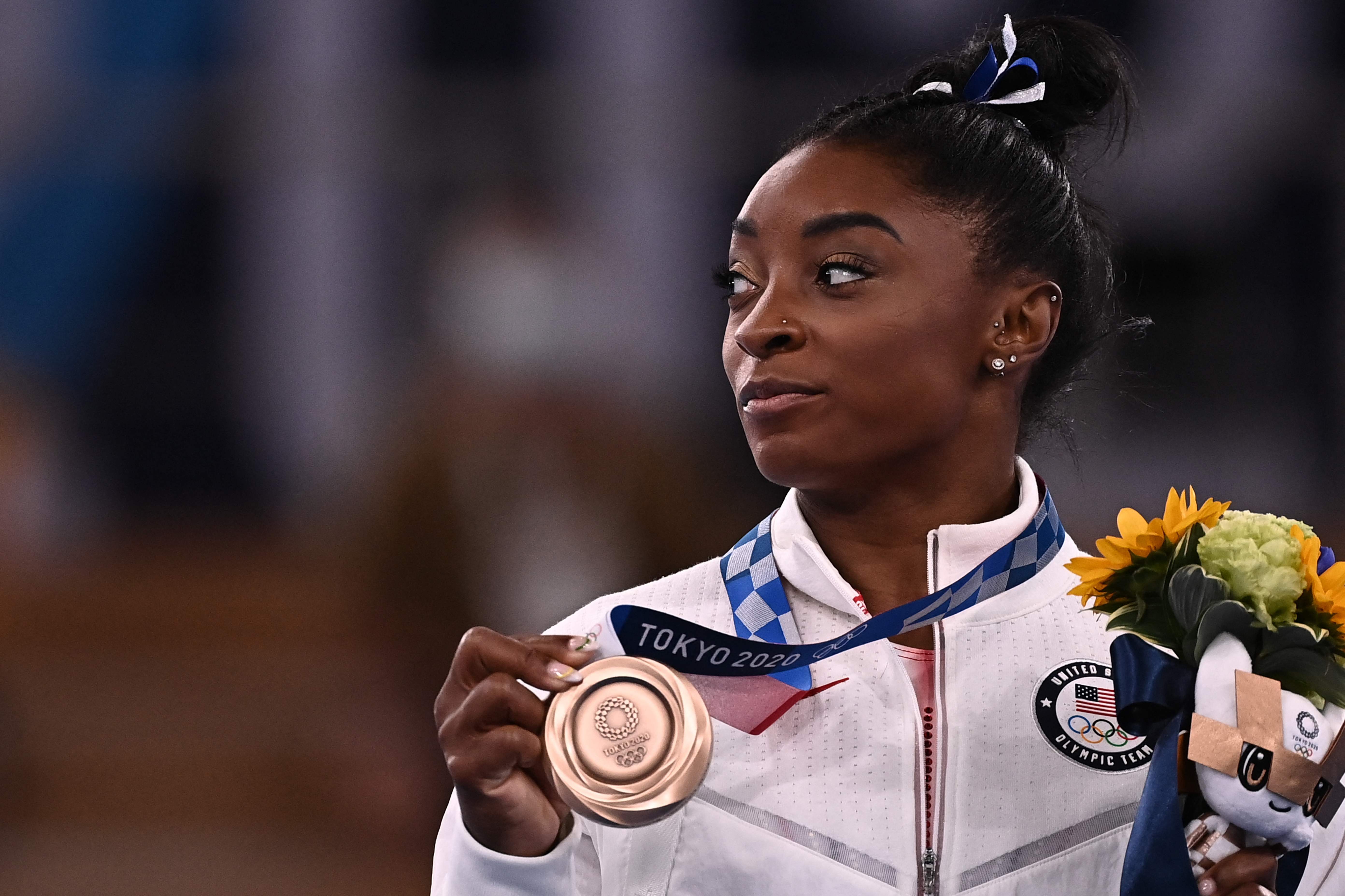 Simone Biles posa con su medalla de bronce en los Juegos Olímpicos de Tokio. Foto Prensa Libre: AFP.